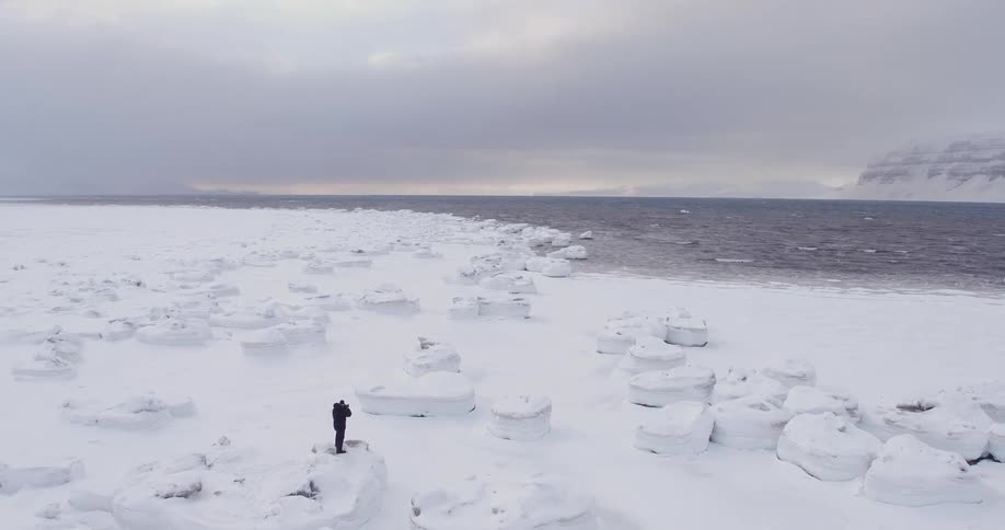 Person walking over rocky snowy land