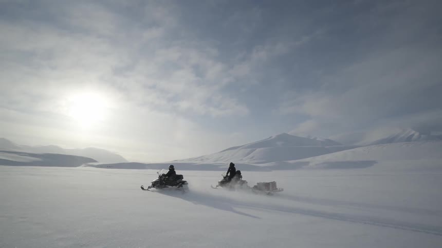 People riding on snowmobiles in the arctic