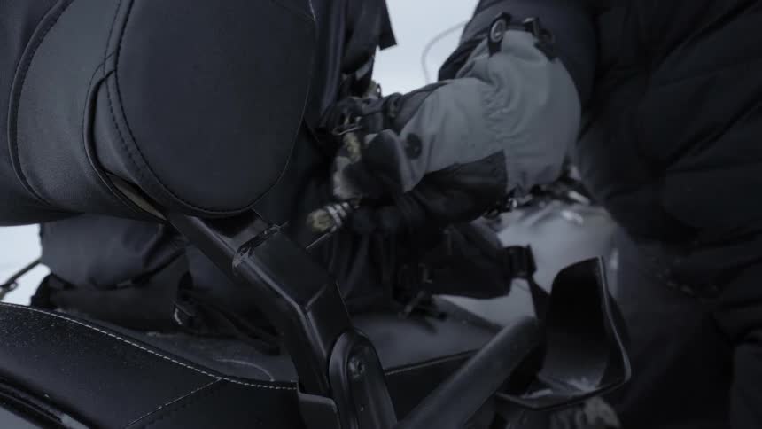 A person latches bags to a vehicle