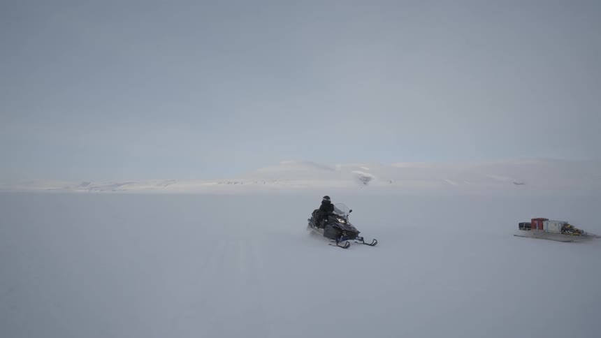Snow mobiles race in the snow together