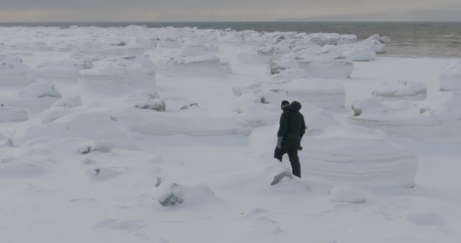A photographer walks in the snowy wilderness