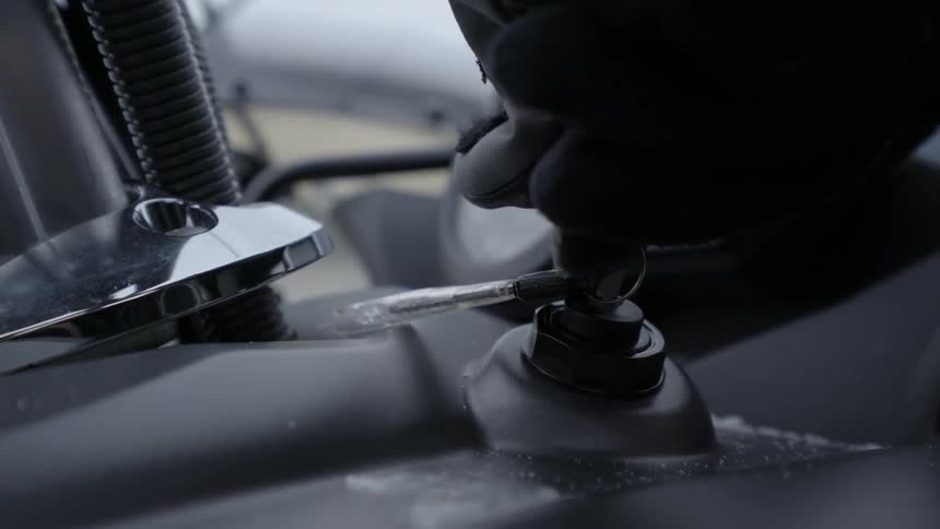 A person turns the key in an ignition