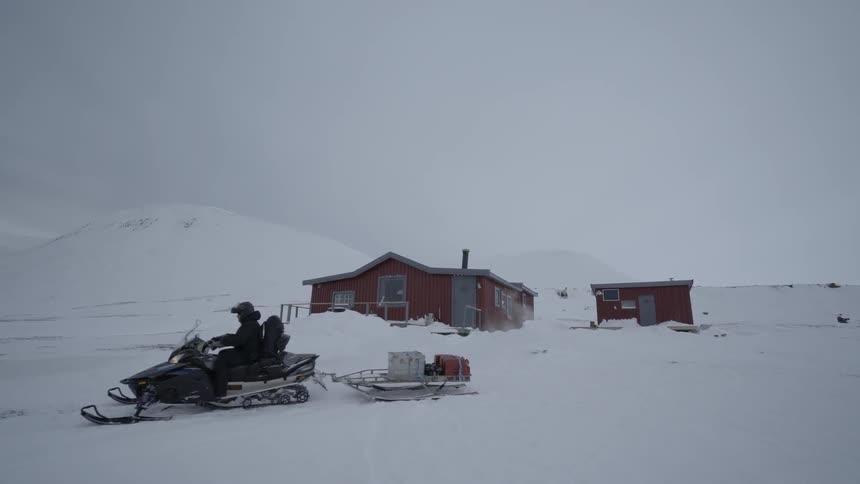 A sled drags some bags in the snow