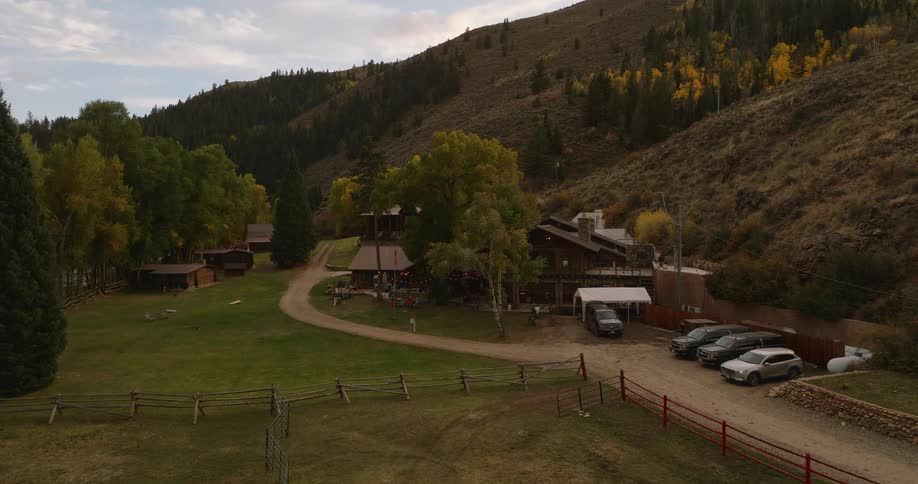 Cabin style lodge surrounded by trees and hills in a quiet rural setting