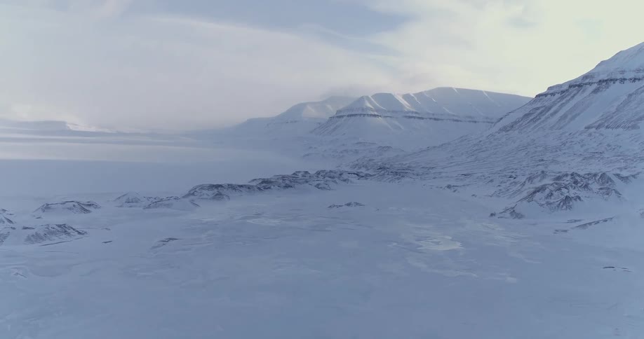 The mountains near the field are covered with snow