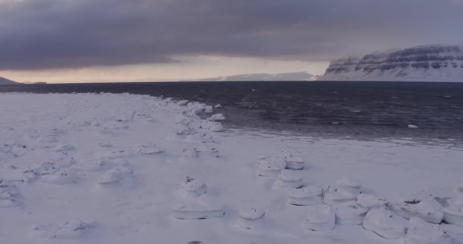 A snow covered area with water next to it