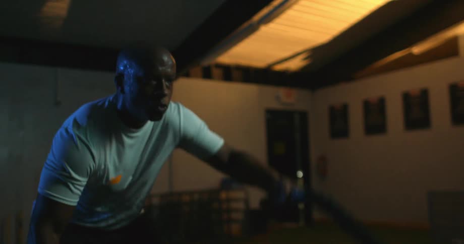 A man is working out pulling some heavy ropes