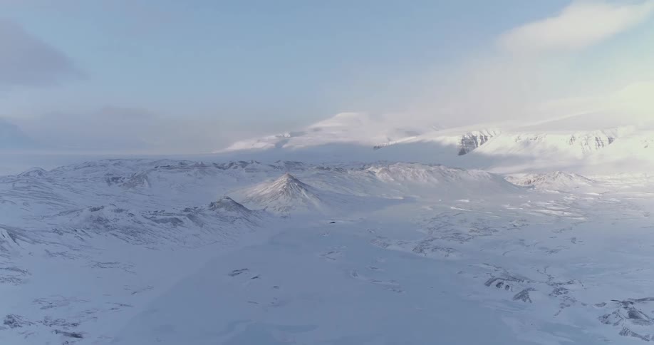 The field below is covered with ice and snow on a sunny day