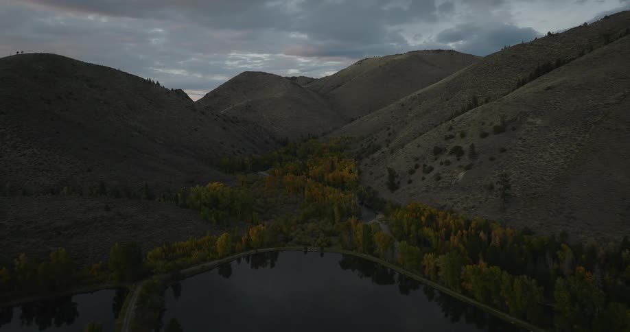 Aerial landscape on a cloudy day of a lake surrounded by conifers and mountains