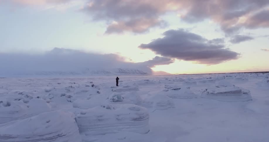 A man stands in a snowy icy field