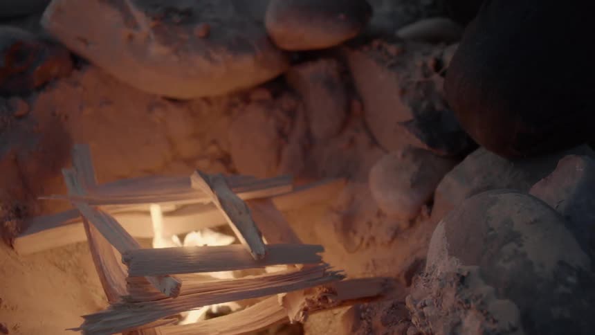 A happy man started a campfire