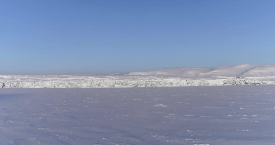 A long snowy field leads to mountains