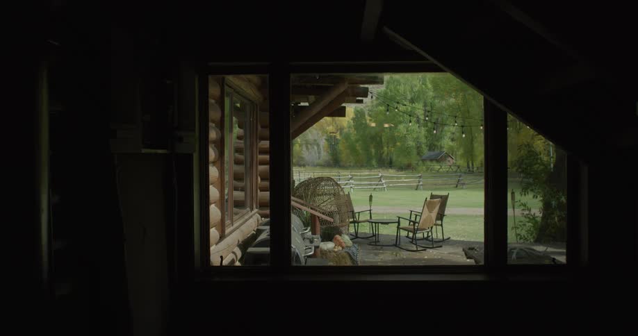 Interior view of a chalet overlooking a natural area with trees