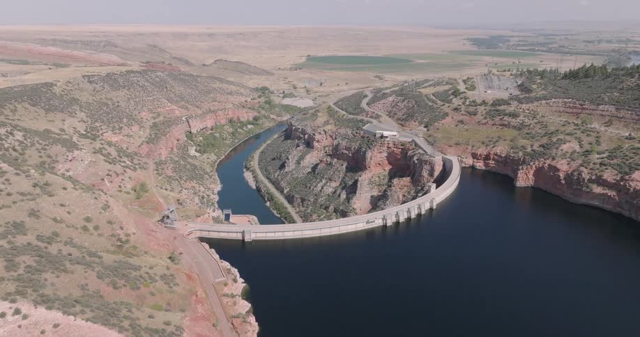 A large dam is in the river by the canyon