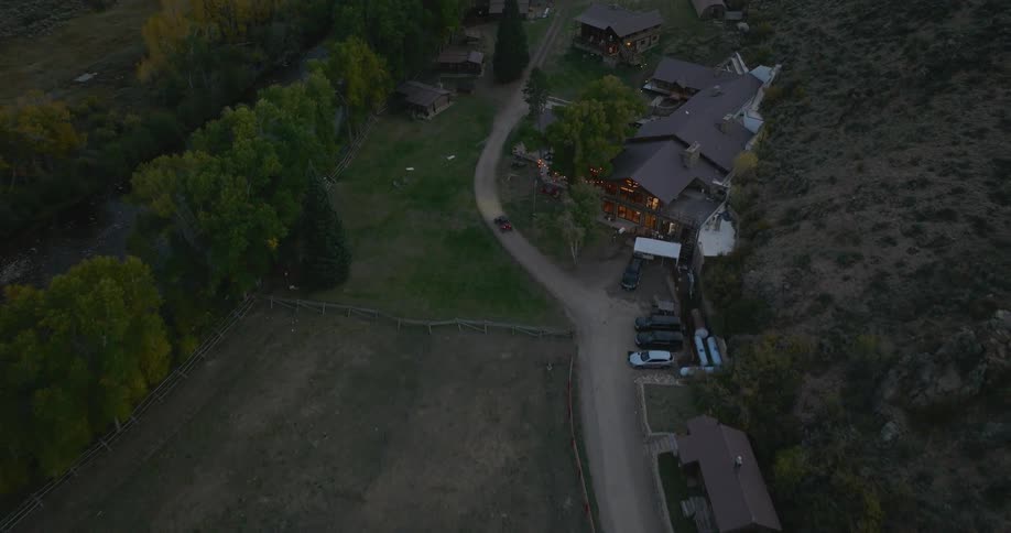 Aerial view of resorts in a natural area at the foot of a mountain and on the banks of a river
