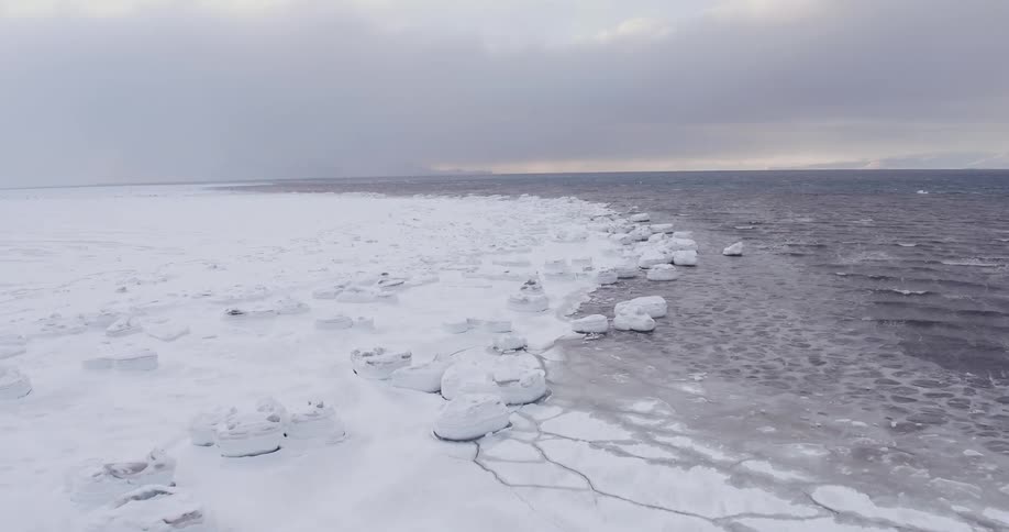 View of a snowy coastline on a cloudy day