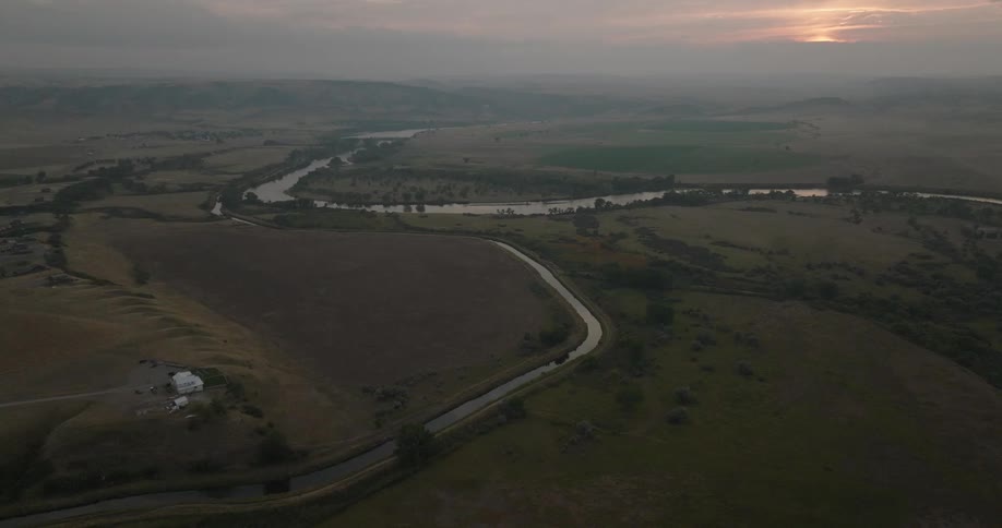 Aerial view of rivers winding through natural and green areas at dawn