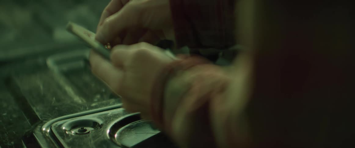 Pair of hands of a person picking up a small fishing tackle