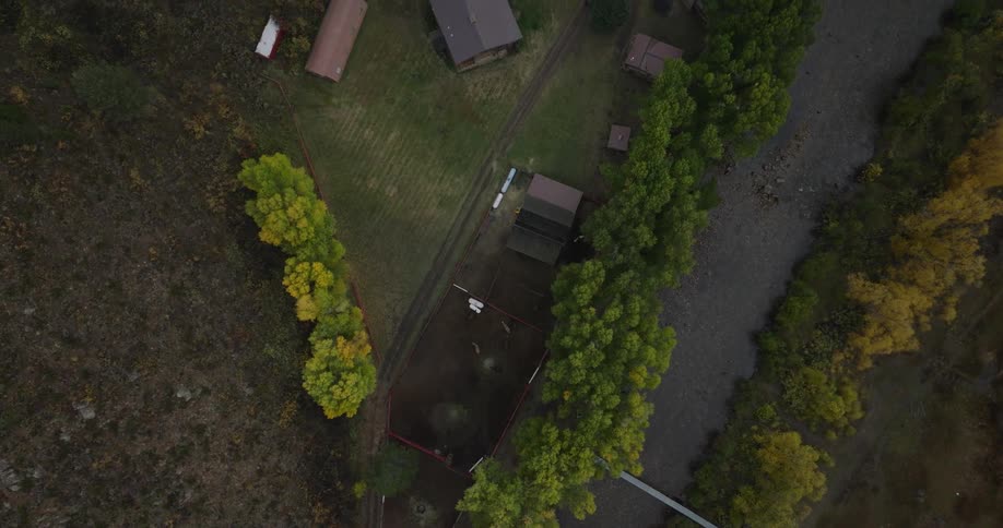 Top down aerial view of a rural property near a tree lined river