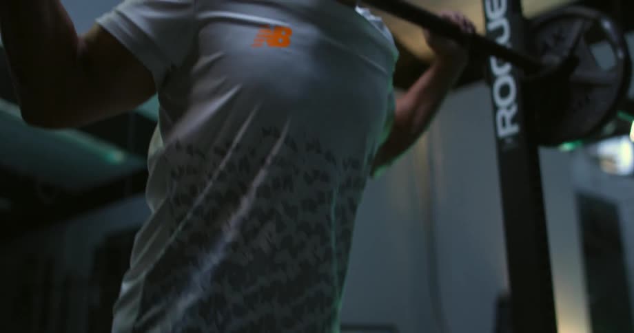 A man ducking underneath and lifting a barbell
