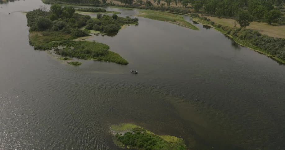 The boat is off the shore in the river