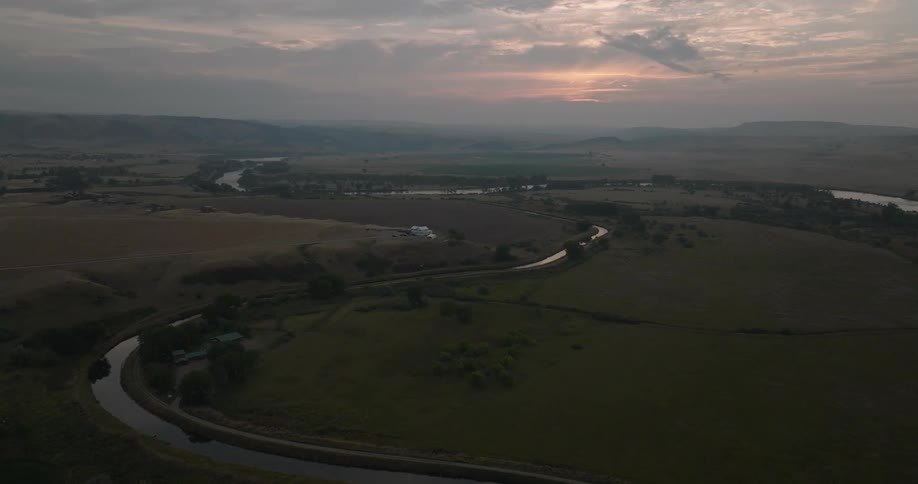 Aerial view of green fields with a winding river