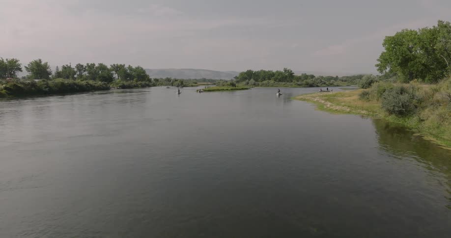 Landscape of a river with people in canoes in the background