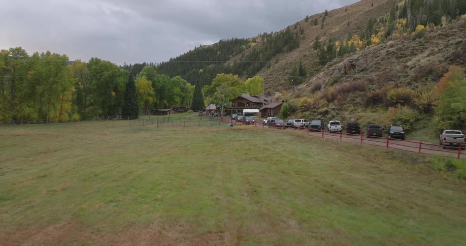 Cars are driving away from the cabin by the mountain