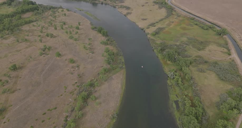 Aerial view of a river winding through dry and green patches of rural land