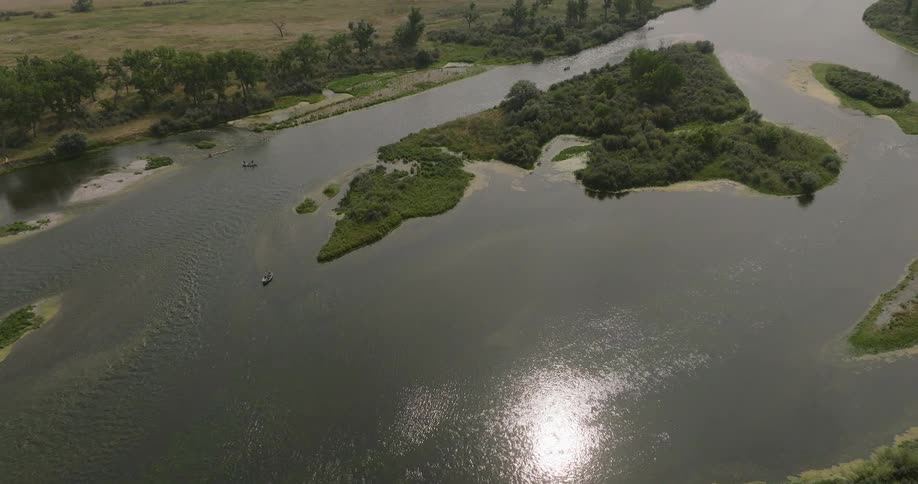 Aerial view of a small body of water surrounded by a rural grassy area