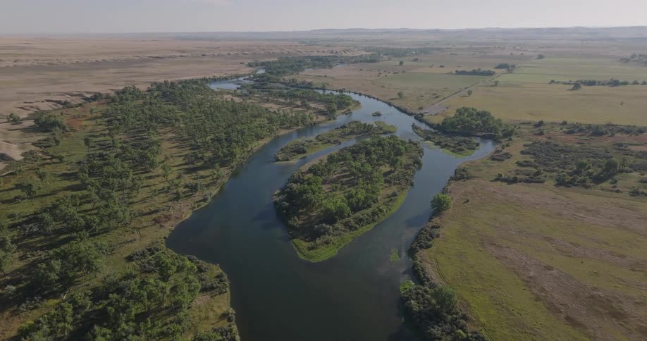 Aerial view of a river winding through green areas