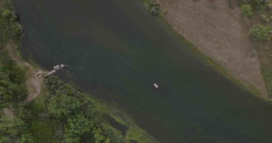 A single boat is in the middle of the stream