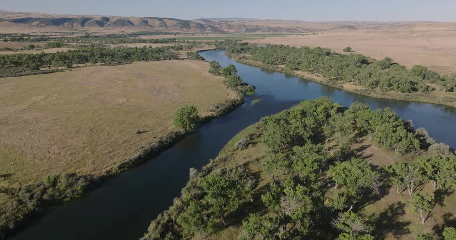 A river splits into a fork to go around a tree covered island