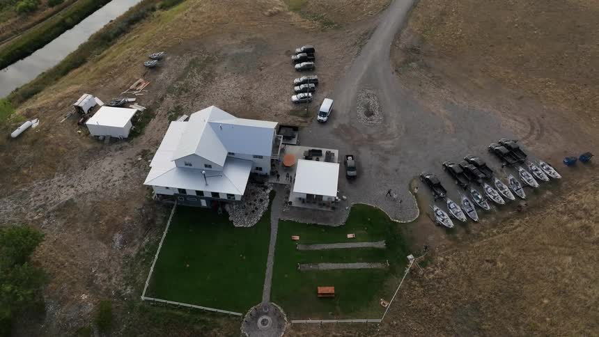 Aerial shot of a house with parked vehicles and people walking