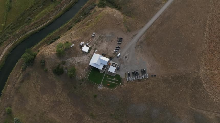 House in a rural setting with vehicles around