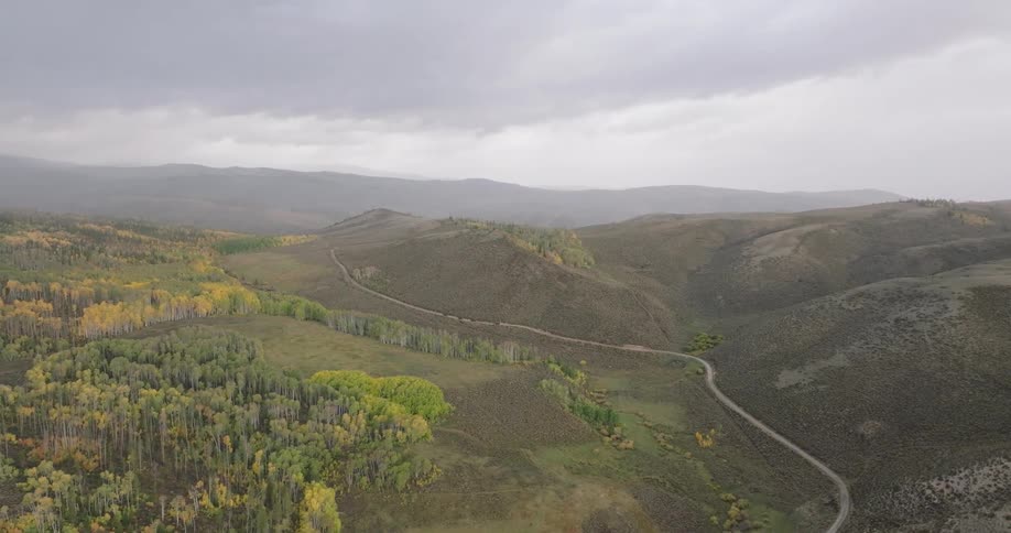 Aerial panorama and a winding road through the forested mountains