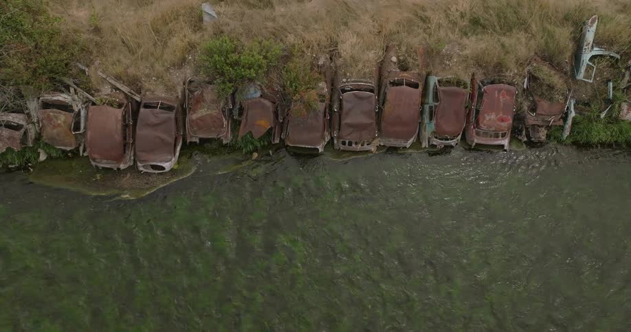 Rusty cars on the edge of a river
