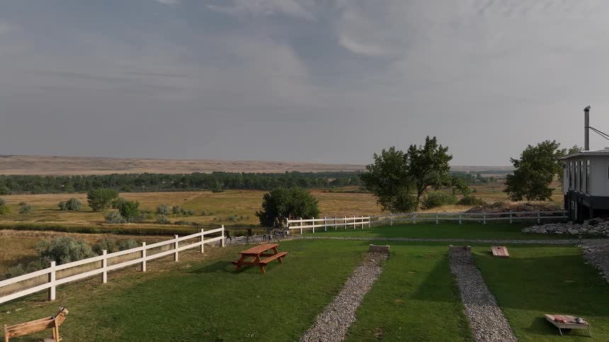 House in a natural environment with agricultural fields and mountains on the horizon