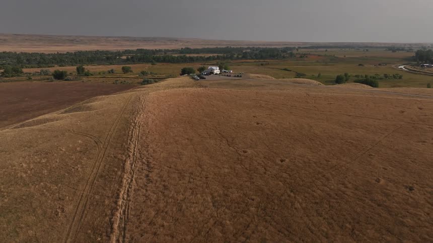 A home on the farm has cars parked around it