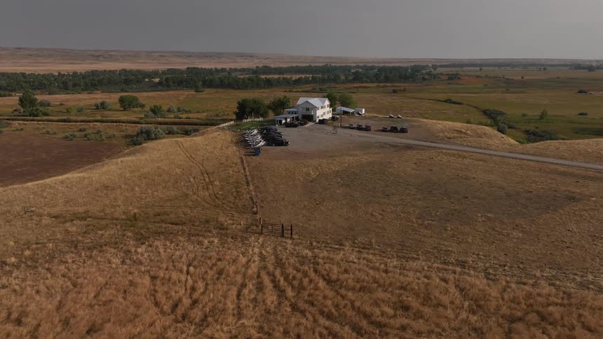 A home has a line of trucks with boats attached in the yard