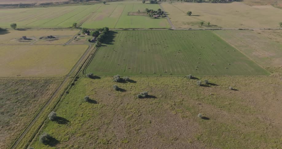Aerial view of farmland with fields trees and hills