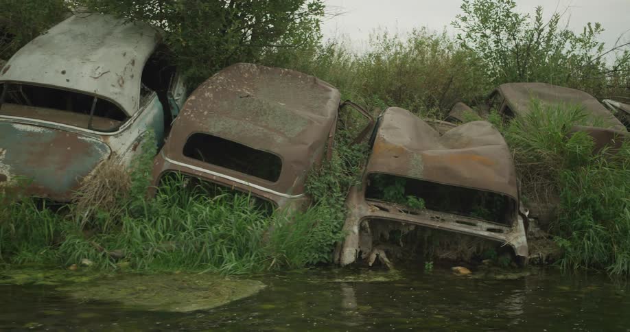 Rusty vehicles on the banks of a river
