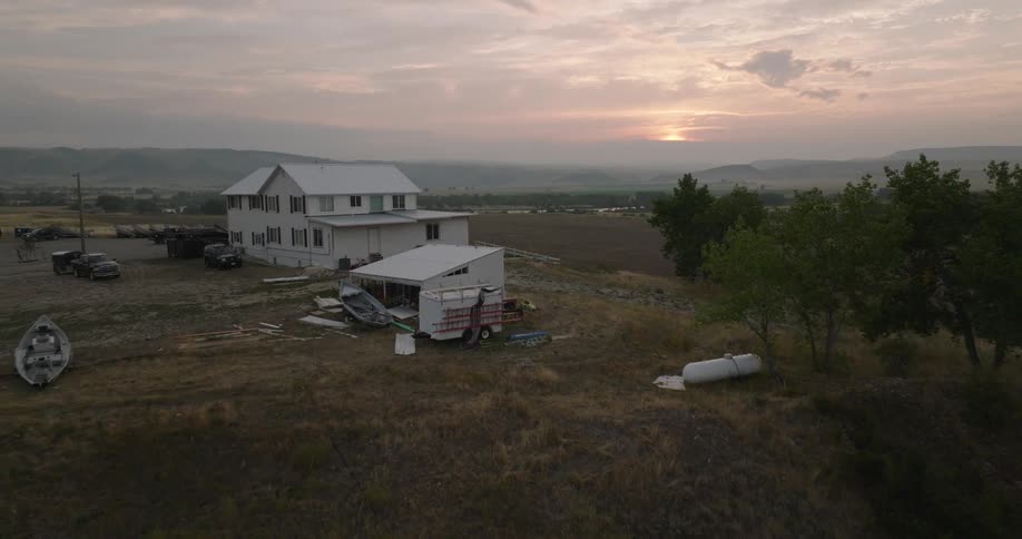 House with vehicles parked around it on a hill in a natural environment