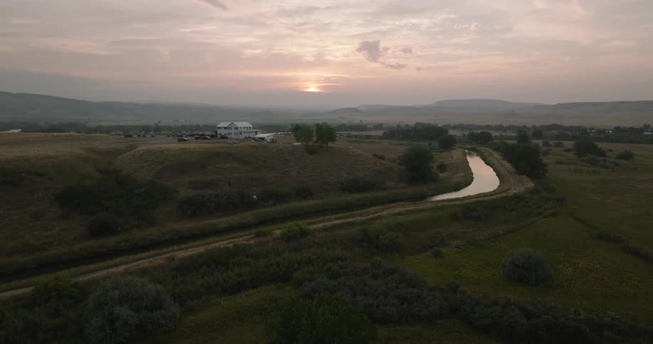 Aerial view of a winding river and a house in the background in a rural area
