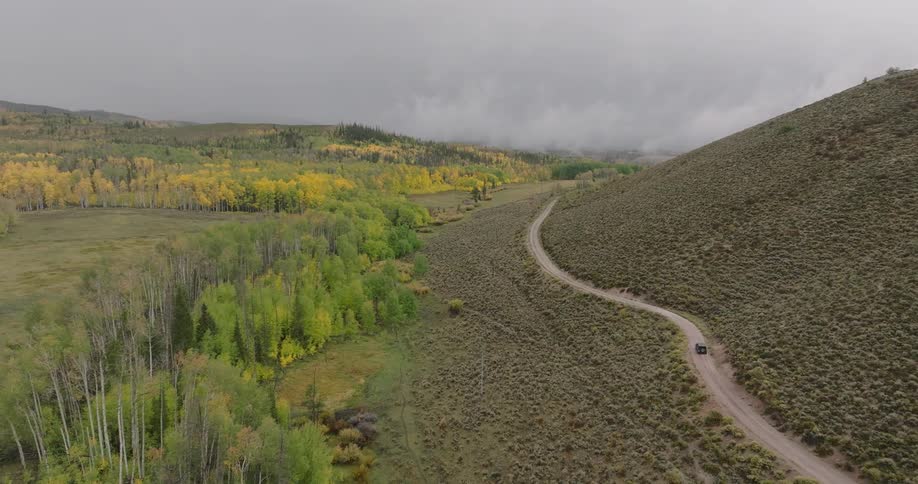 A large vehicle drives on the dirt road