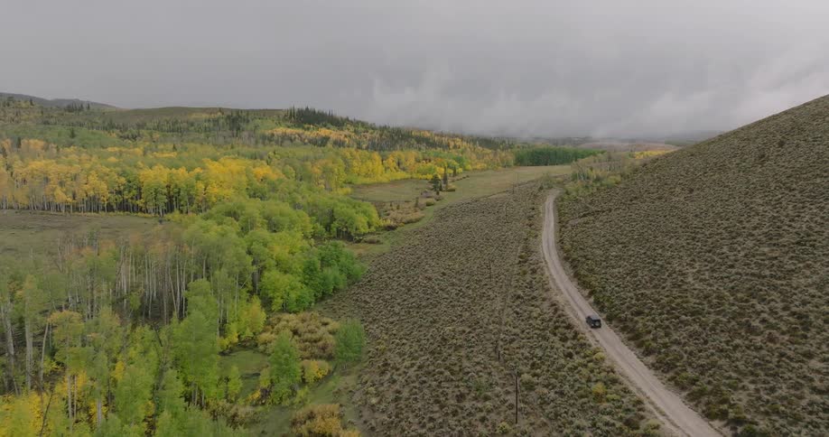 Isolated car traveling in a natural environment of mountains and forests