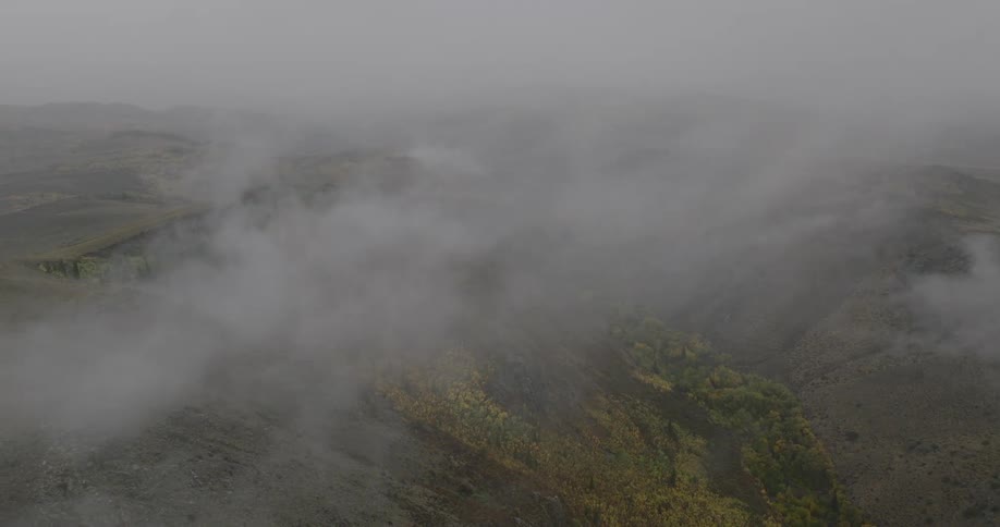 Heavy fog covers the green mountains
