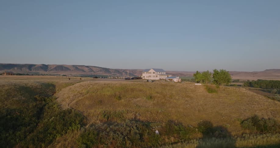 White house sits on top of a hill near the river