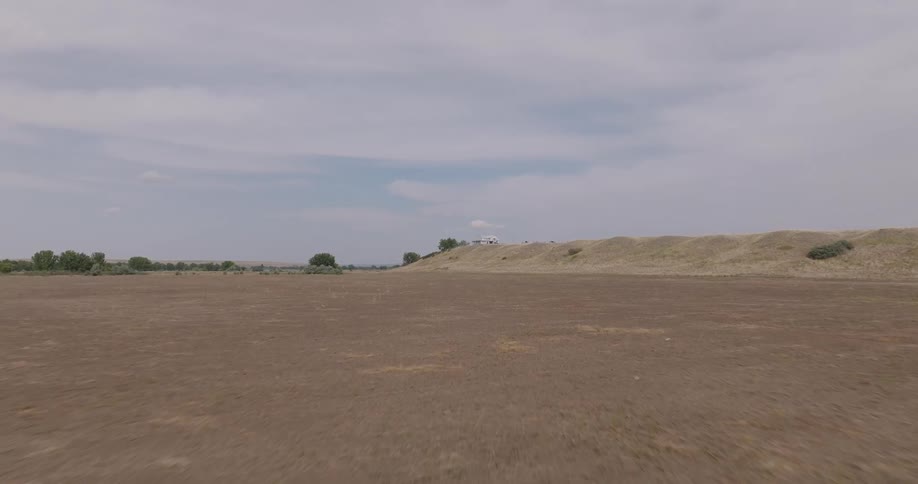 Natural area of land with trees on the horizon on a partly cloudy day