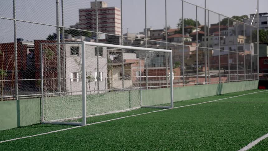 A netted goalpost on an outdoor soccer field during daytime
